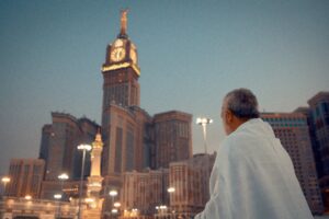 a man looking at the clock tower in Mecca